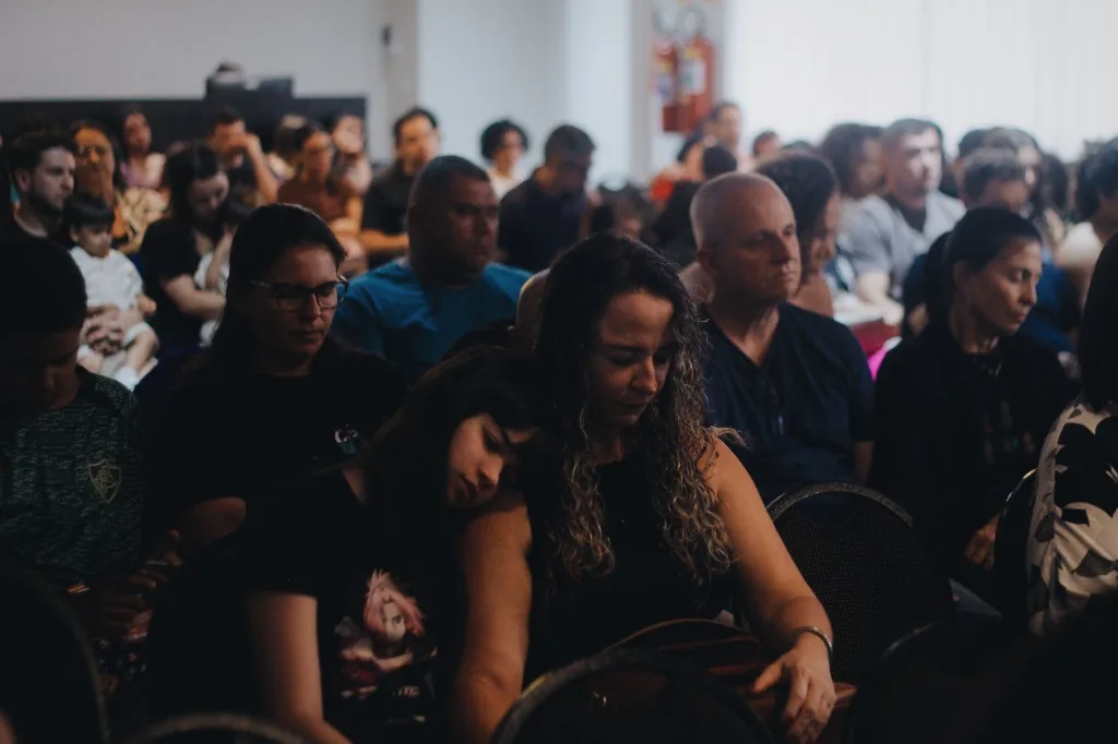 Famílias e comunidade reunidas em oração e culto na CBM